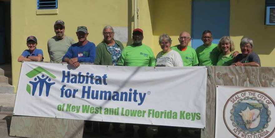 group of people standing in front of sign for Habitat for Humanity