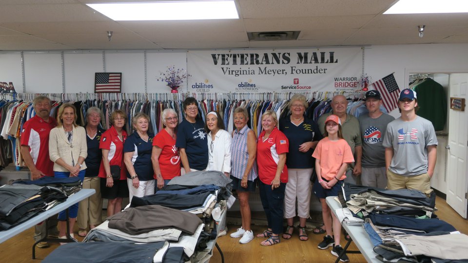 large group of people standing in front of clothing rack