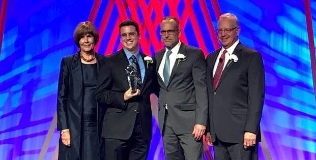 people standing on stage holding award