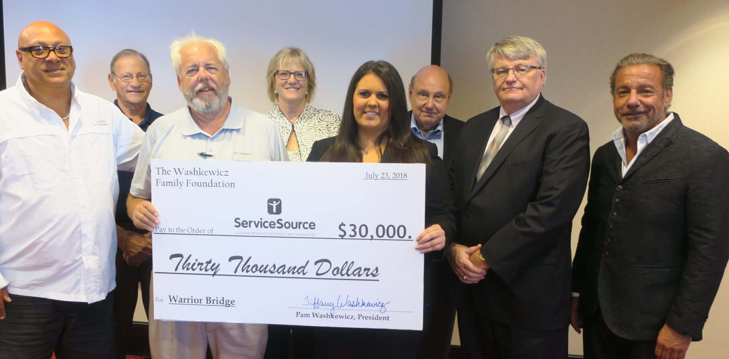 group of people holding large check