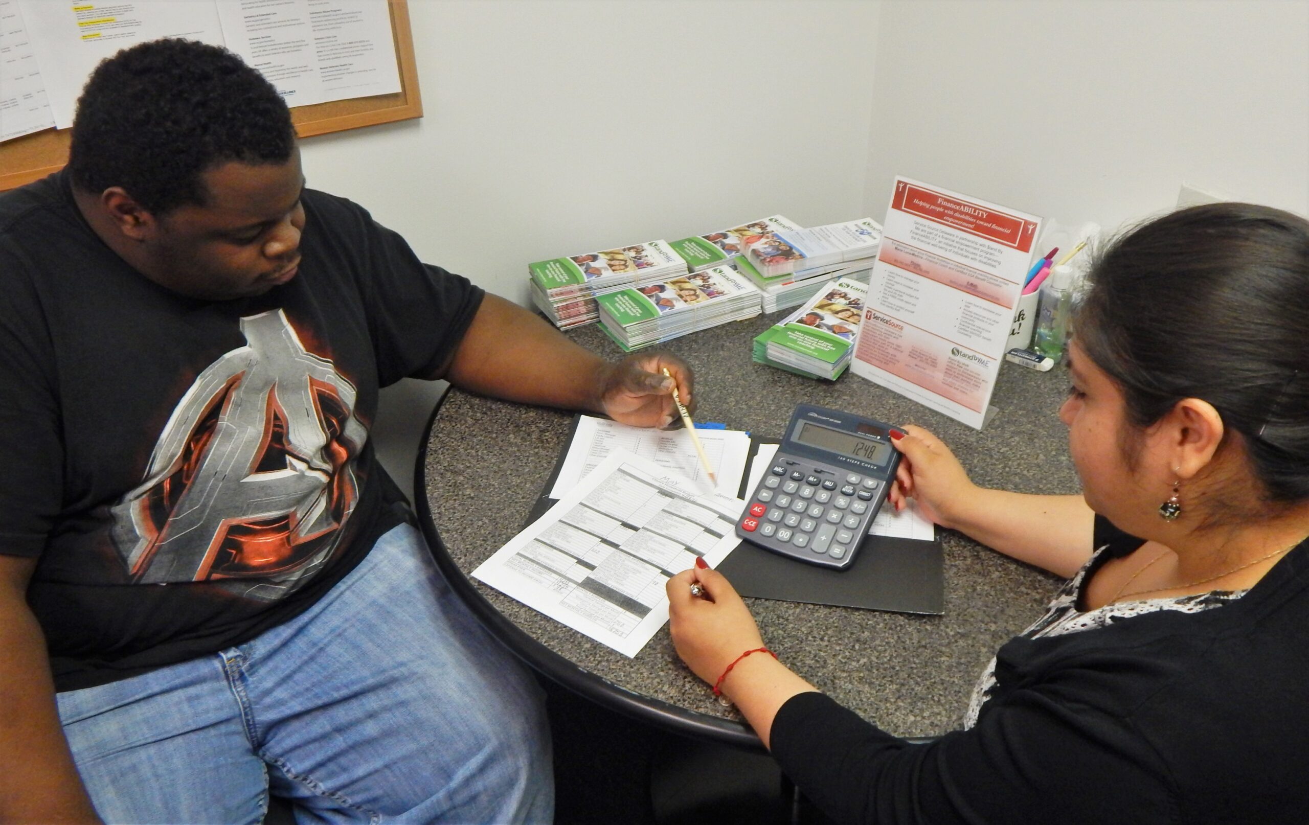 two people looking at paper and calculator