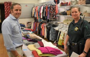 Two people standing in front of clothes and shoes