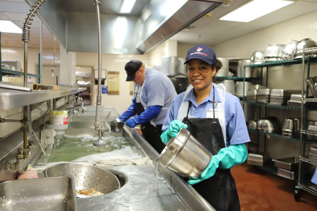 person holding silver bucket smiling at camera