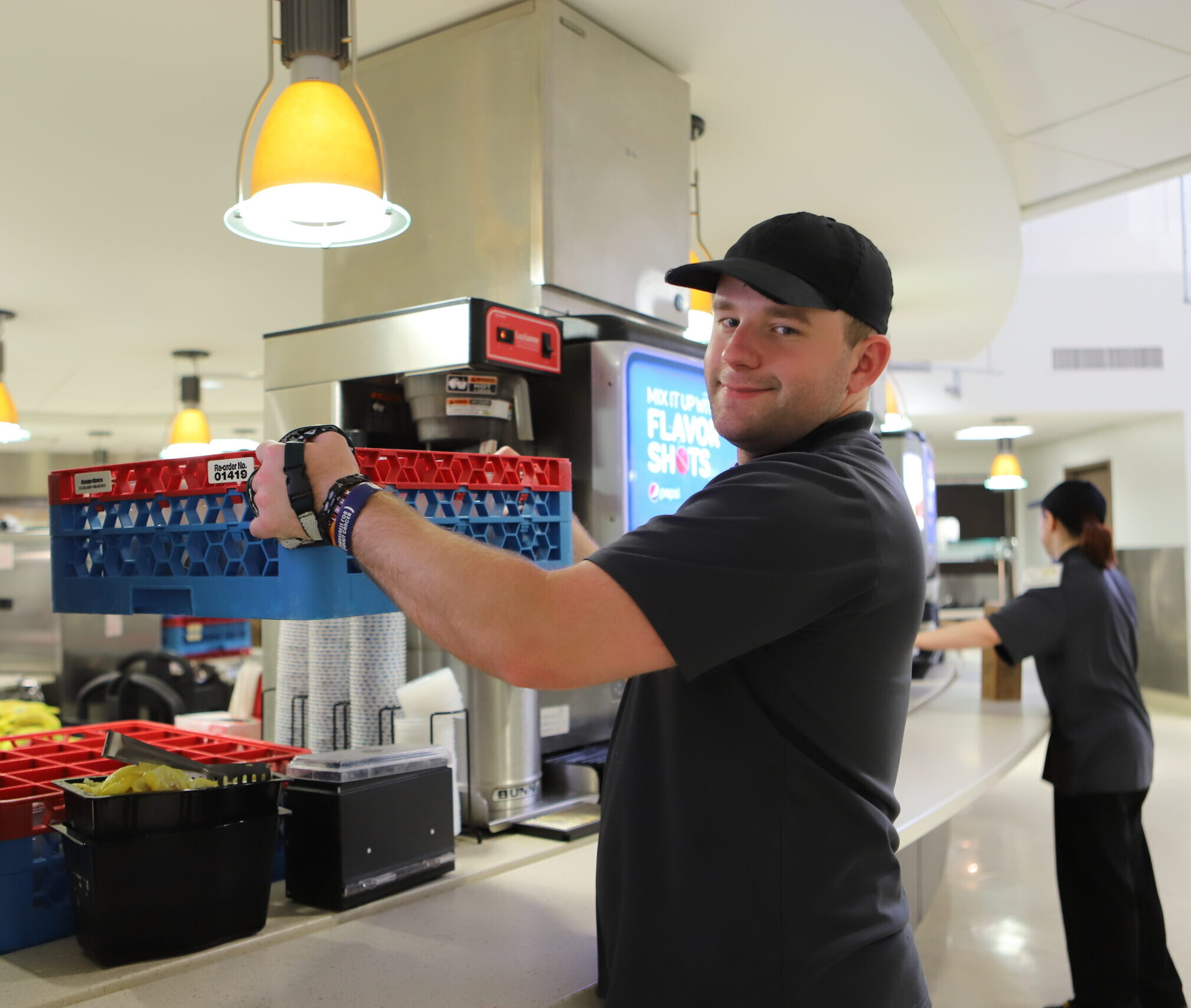 person holding up drink crate smiling at camera