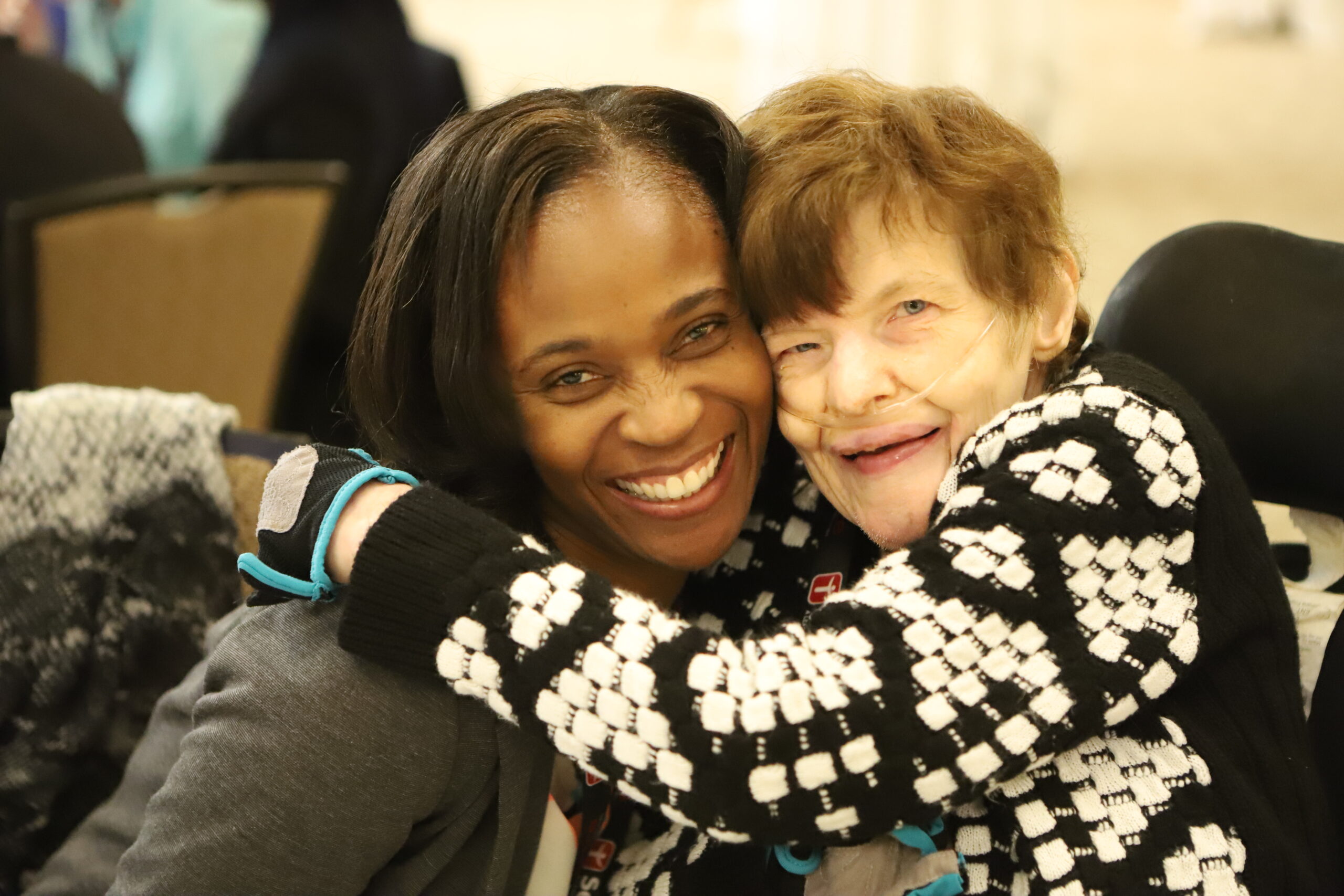 two people hugging while looking at camera