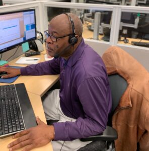 man looking at computer screen with headset