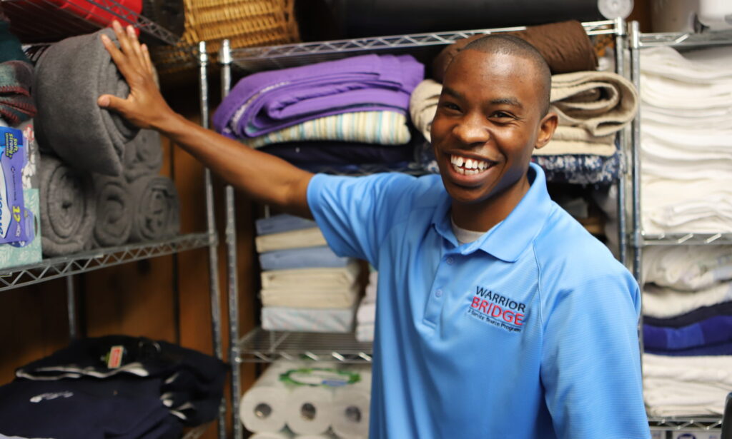 man smiling at camera with hand on wrapped blanket