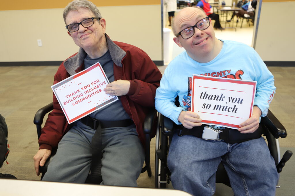 two people holding thank you signs
