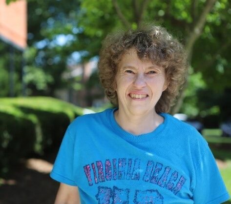 Woman in blue shirt smiling at camera