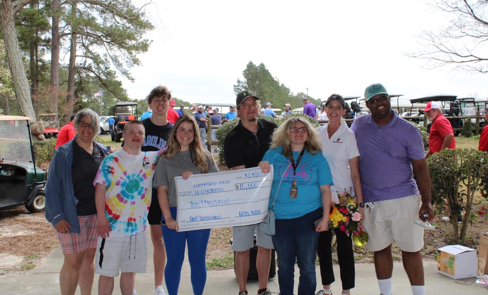 Group of people holding large check