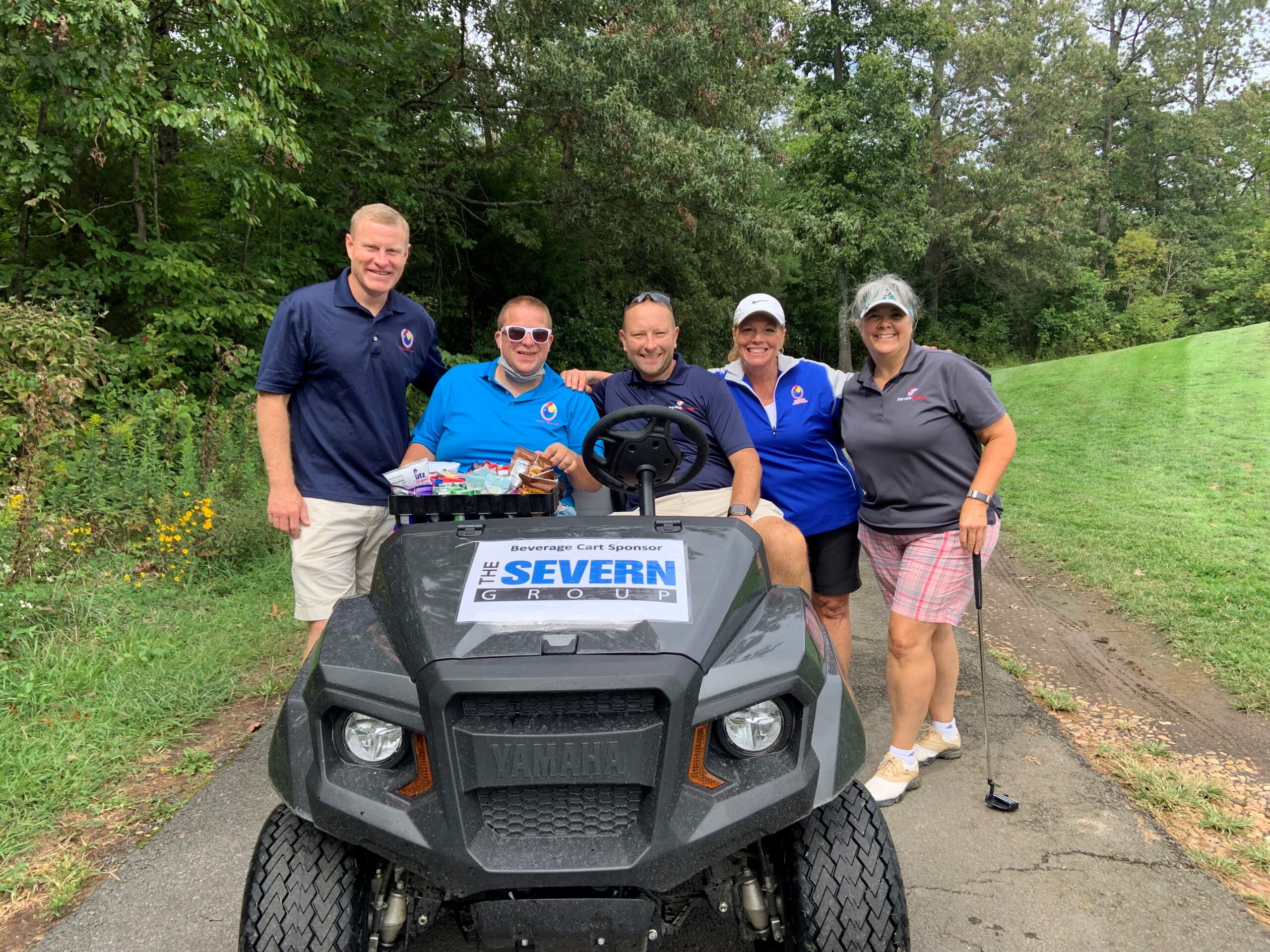 Group of people surrounding golf cart