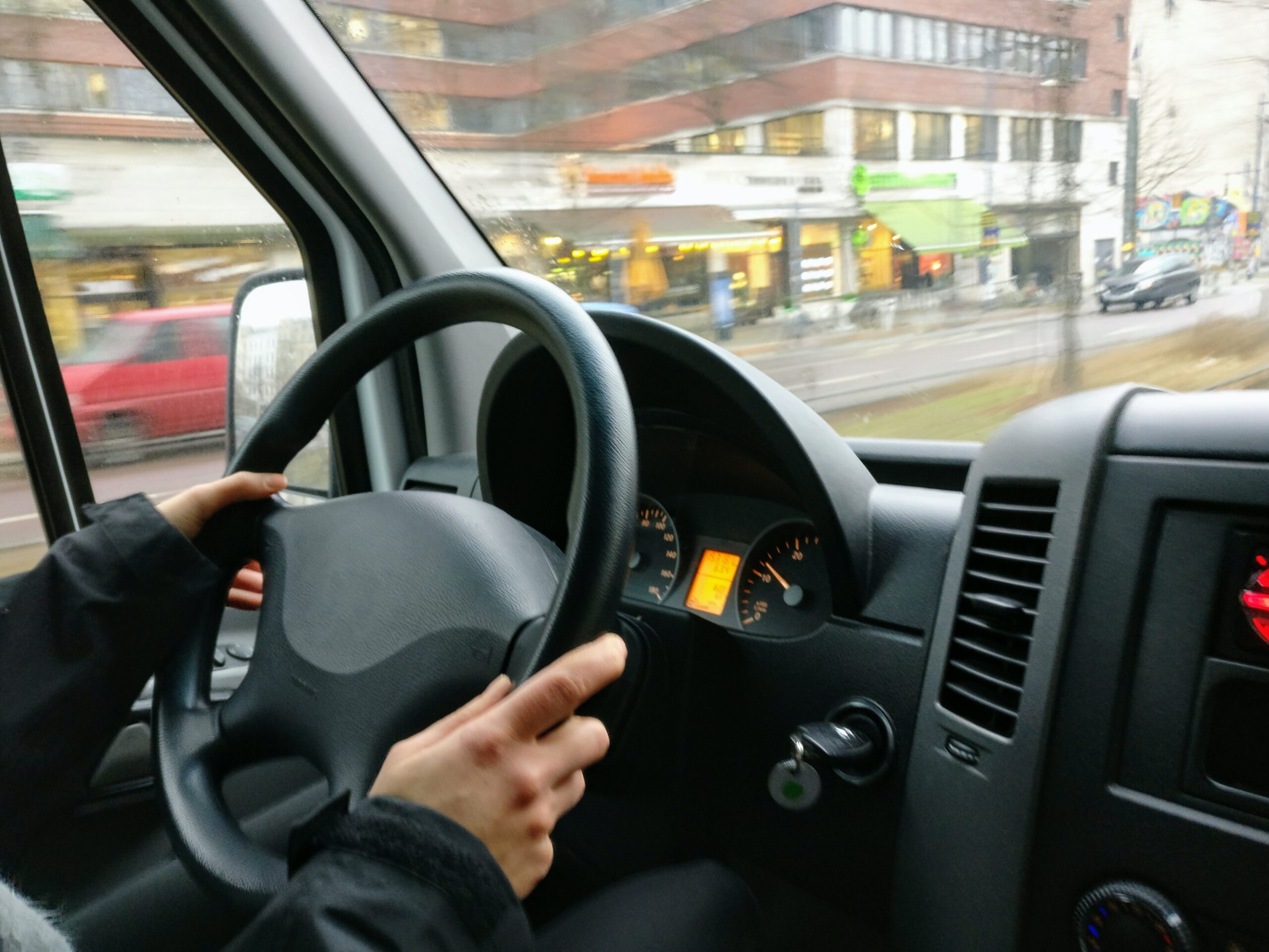 Person with hands on the wheel of car