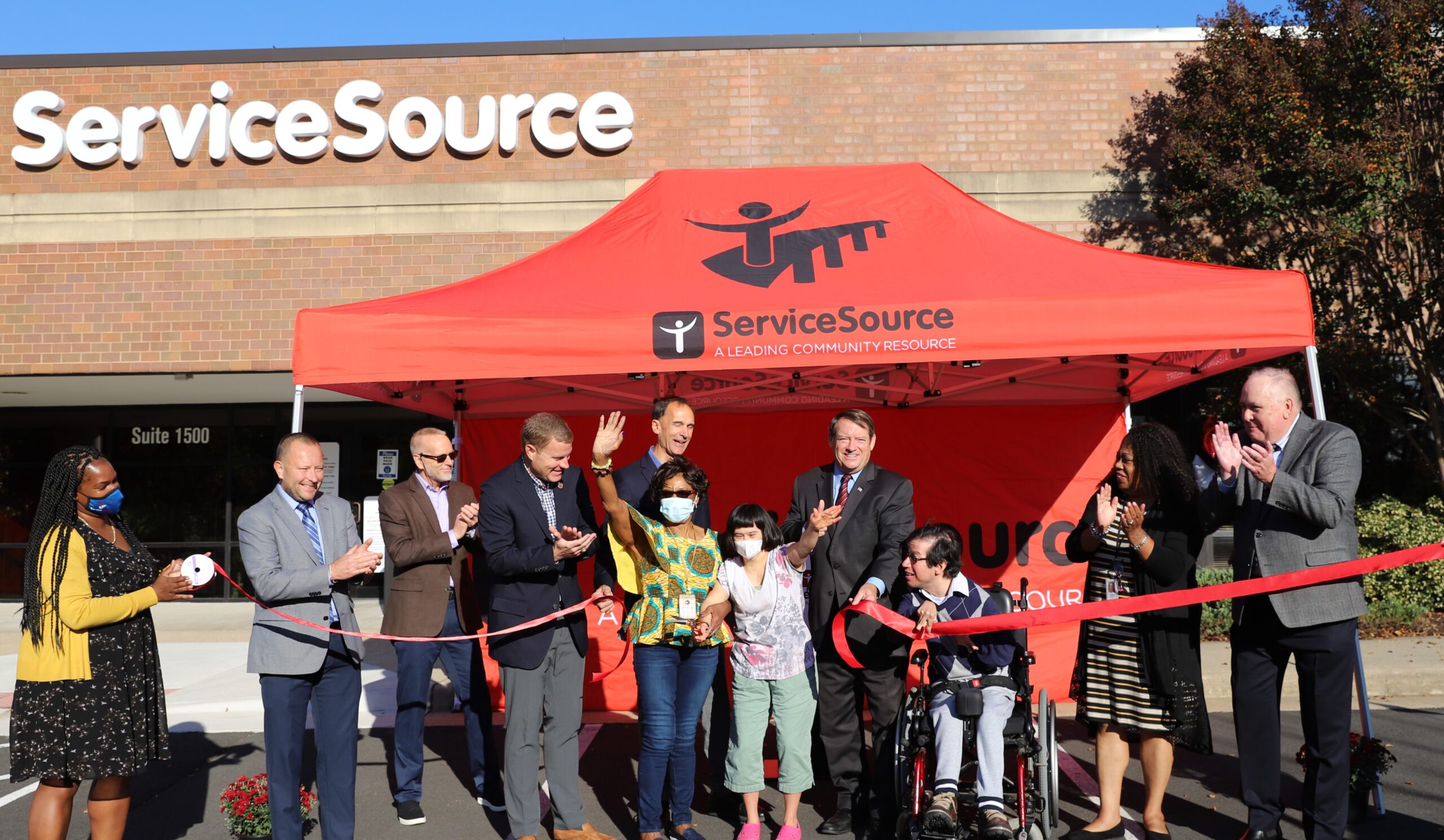 Group of people standing in front of cut ribbon