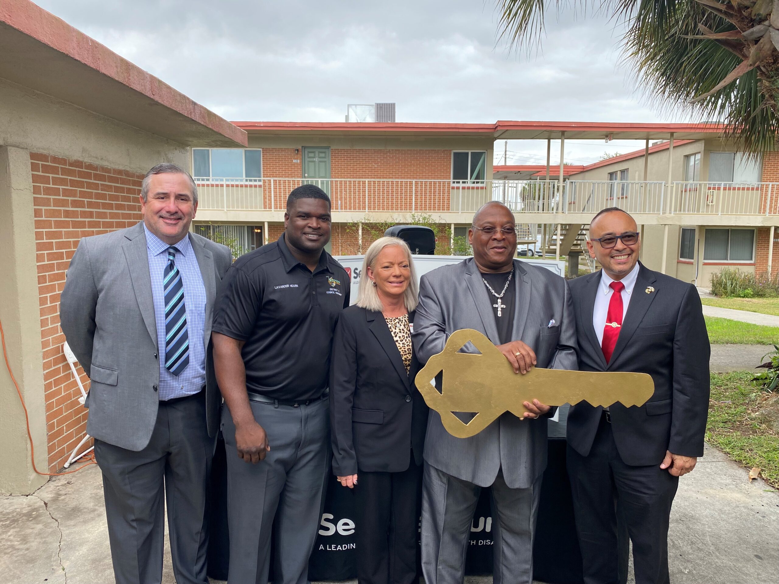 Group of people holding large key