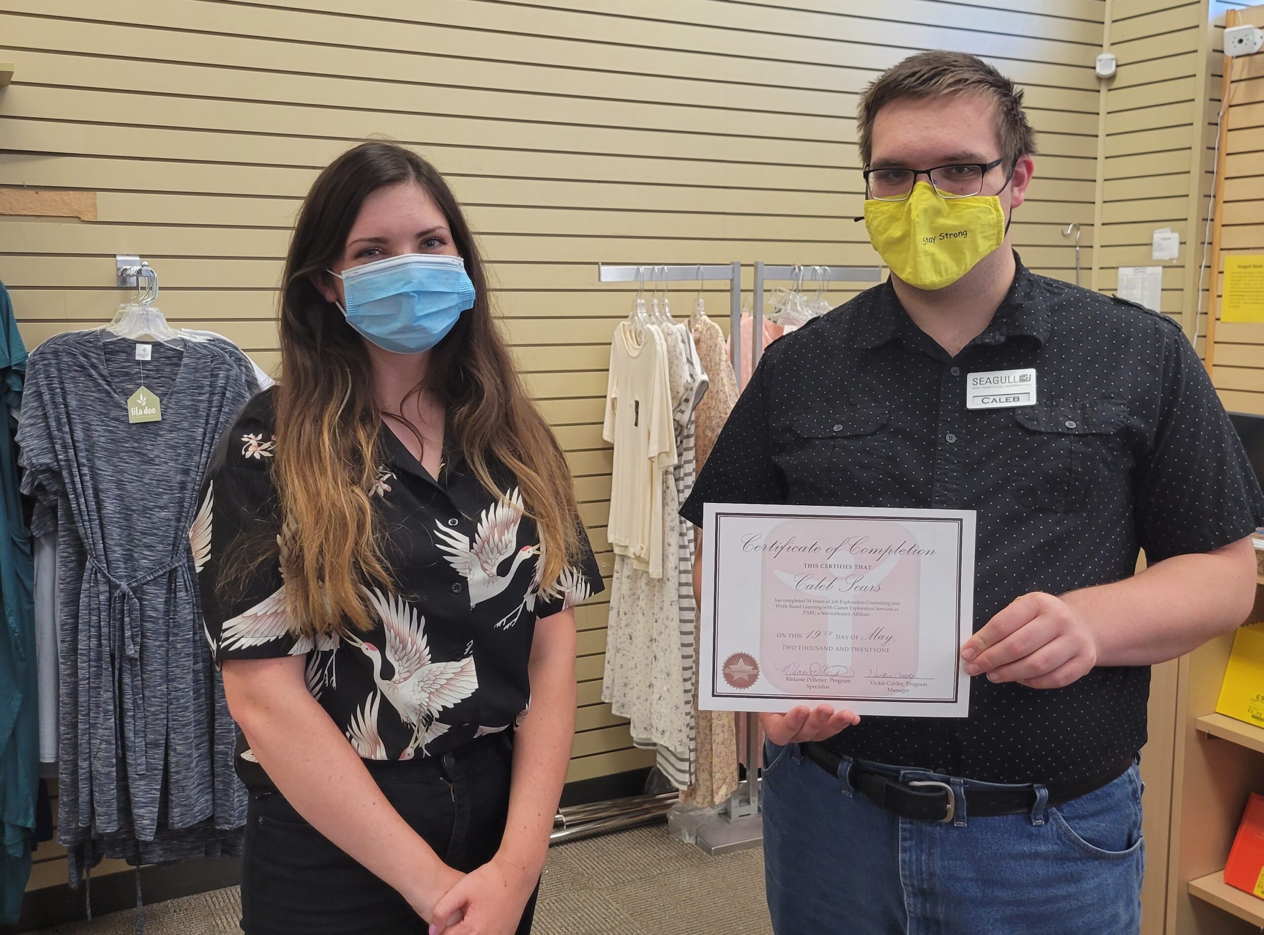 Two people standing next to each other holding a certificate