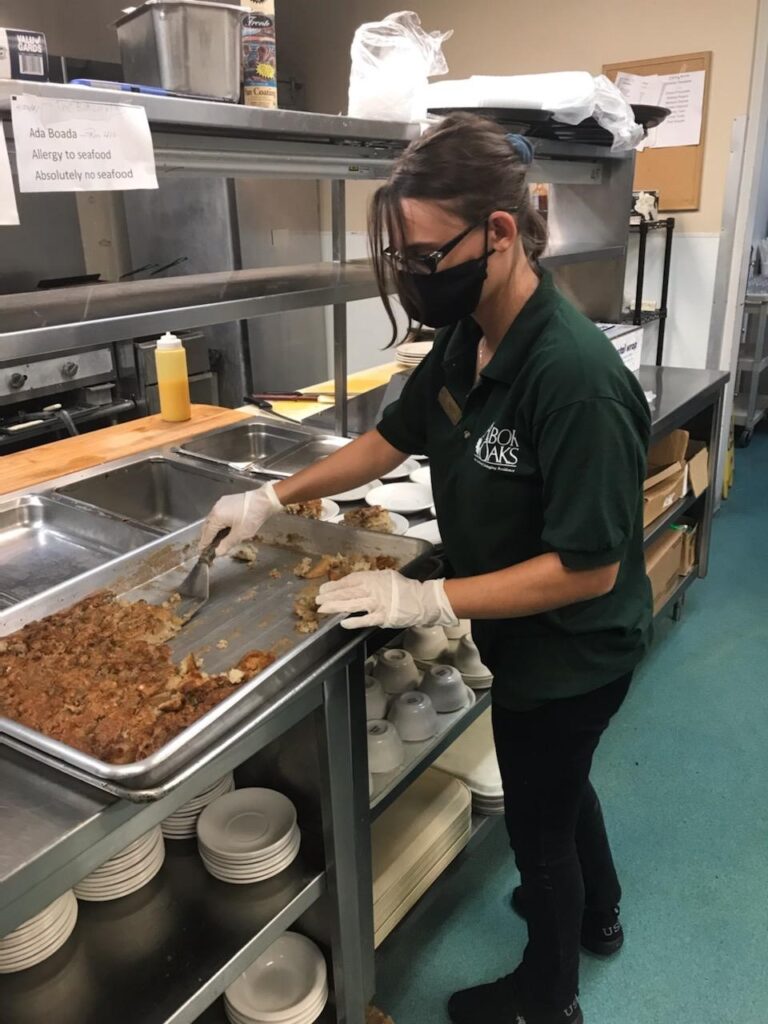 Person in kitchen serving dessert