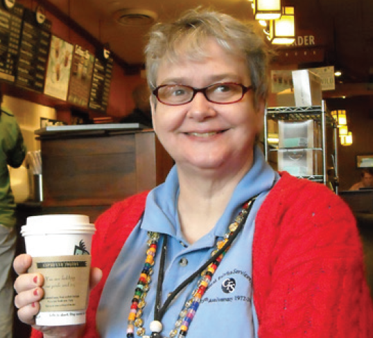 woman smiling holding coffee cup