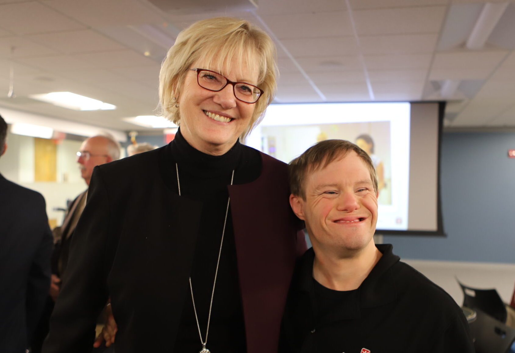 Two people smiling at conference room