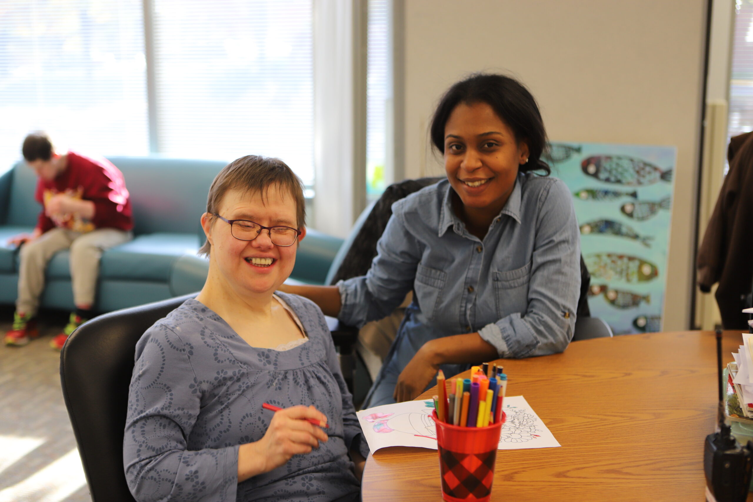 Two people sitting at desk posing for camera