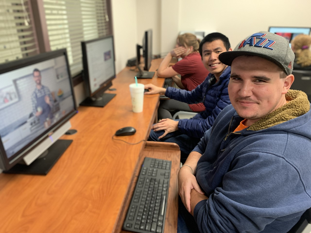 People looking at camera from computer desk