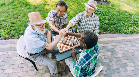 People smiling and playing chess