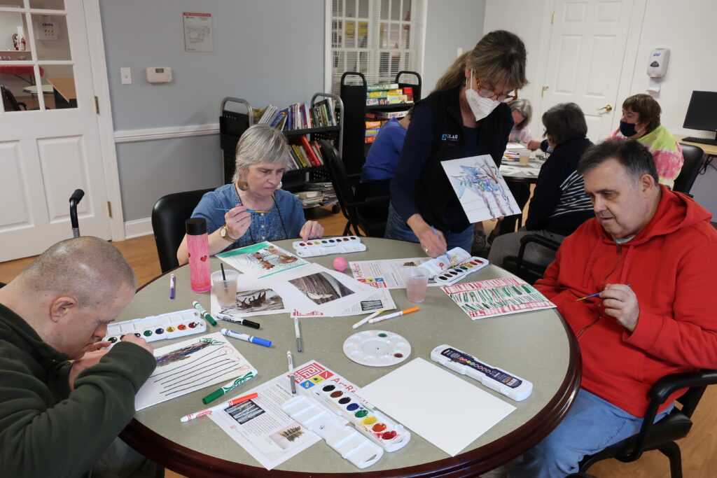 Participants sitting at a round table creating arts